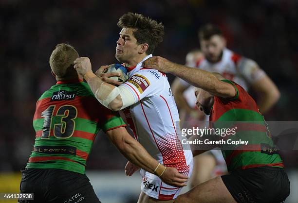 Louie McCarthy-Scarsbrook of St Helens is tackled by Jason Clark and Glenn Stewart of South Sydney Rabbitohs during the World Club Challenge match...