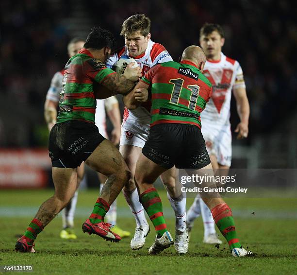 Louie McCarthy-Scarsbrook of St Helens is tackled by Glenn Stewart and Issac Luke of South Sydney Rabbitohs during the World Club Challenge match...