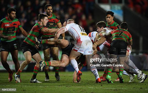 Jason Clark of South Sydney Rabbitohs is tackled by Luke Thompson of St Helens during the World Club Challenge match between St Helens and South...