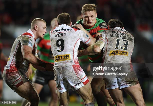 George Burgess of South Sydney Rabbitohs is tackled by Adam Swift , James Roby and Louie McCarthy-Scarsbrook of St Helens during the World Club...