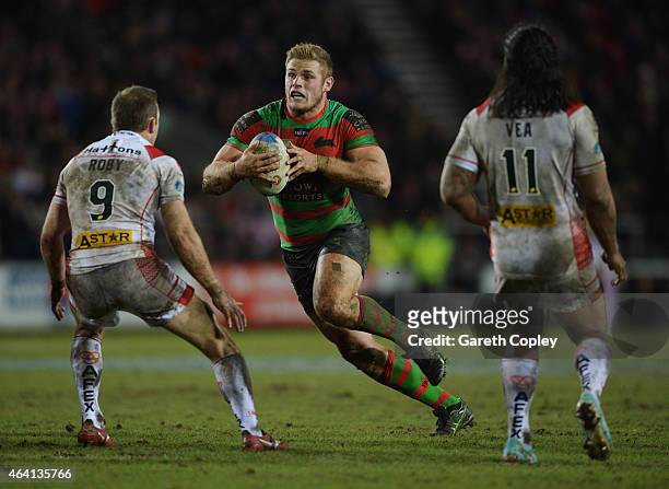 Tom Burgess of South Sydney Rabbitohs runs at James Roby and Atelea Vea of St Helens during the World Club Challenge match between St Helens and...