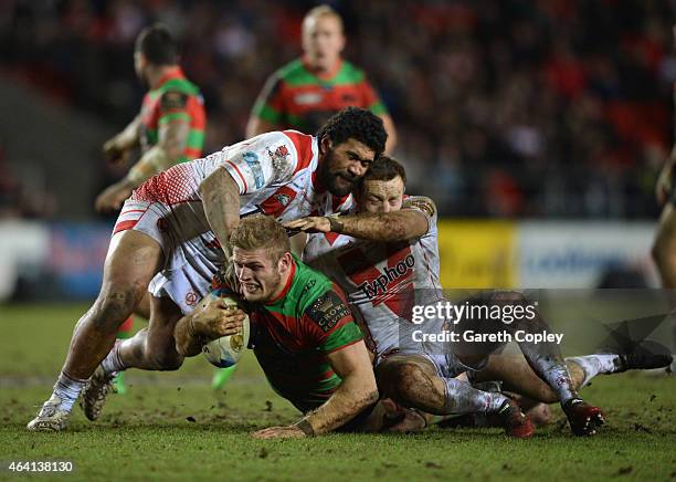 Mose Masoe of St Helens assists in tackling Tom Burgess of South Sydney Rabbitohs during the World Club Challenge match between St Helens and South...