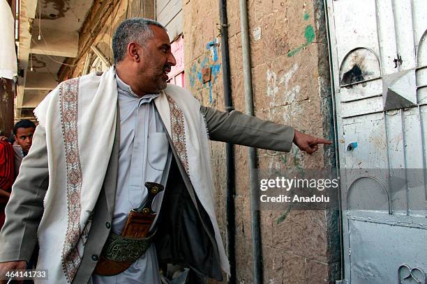 Yemeni man points a bullet hole on a door after Ahmed Sharaf al-Din was gunned down by unidentified gunmen on January 21, 2014 in the Yemeni capital...