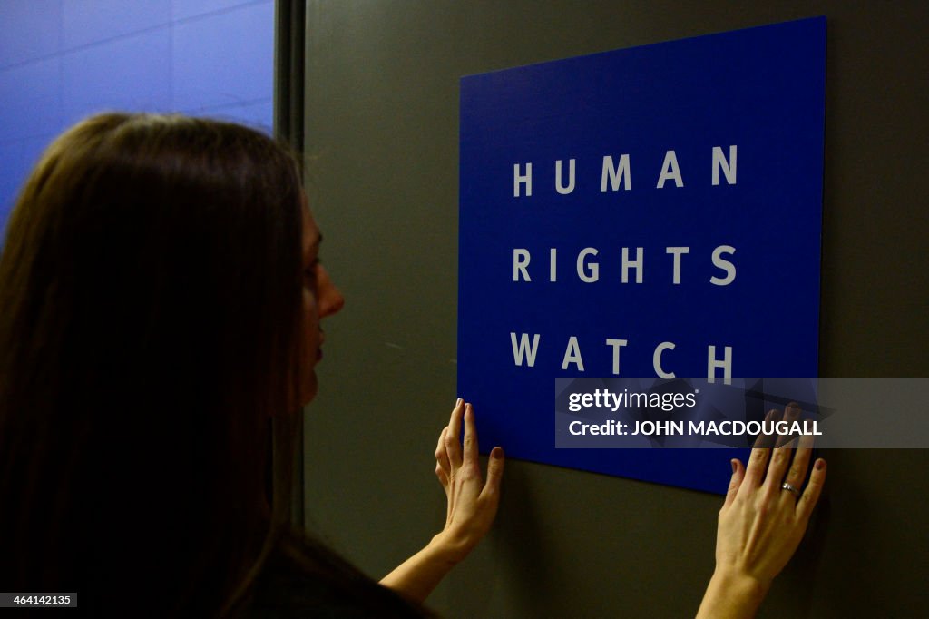 A woman puts a logo of US-based rights group Human Rights Watch on ...