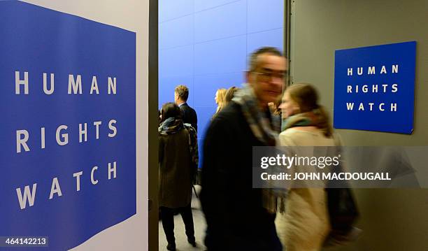 People arrive before the press conference of US-based rights group Human Rights Watch to release their annual World report on January 21, 2014 in...