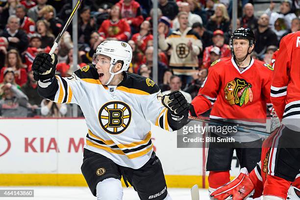 Jordan Caron of the Boston Bruins reacts after the Bruins scored against the Chicago Blackhawks in the second period as Kris Versteeg stands in the...