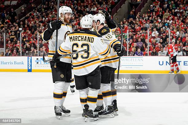 Dougie Hamilton of the Boston Bruins skate in to celebrate with teammates after scoring against the Chicago Blackhawks in the second period during...