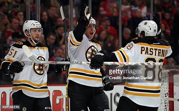 Milan Lucic of the Boston Bruins celebrates a second period goal against the Chicago Blackhawks with teammates Ryan Spooner and David Pastrnak at the...