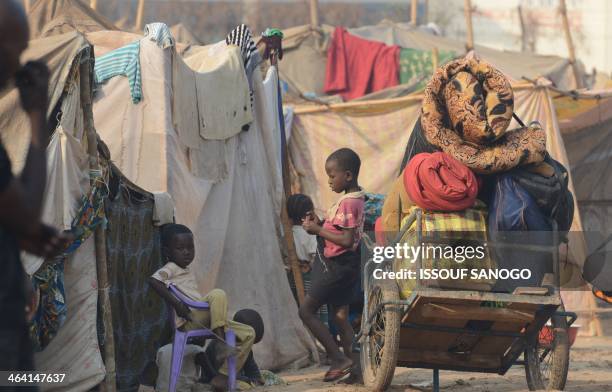 Displaced children stand next to makeshift shelters in the camp for displaced persons near the Mpoko airport in Bangui, on January 21 a day after the...