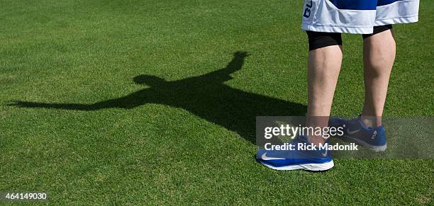 Steve Delabar's shadow on the grass as he loosens up. A day before pitchers and catchers must report to the Toronto Blue Jays spring training...