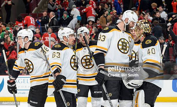 Captain Zdeno Chara and goalie Tuukka Rask of the Boston Bruins celebrate with the team after defeating the Chicago Blackhawks 6-2 during the NHL...