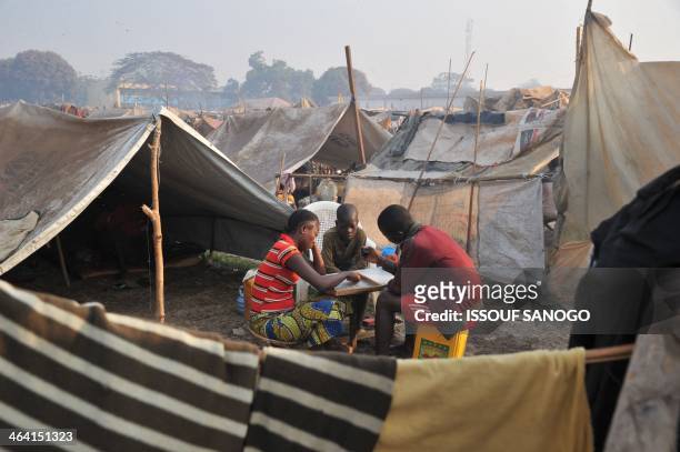 Children play next to makeshift shelters in the camp for displaced persons near the Mpoko airport in Bangui, on January 21 a day after the election...