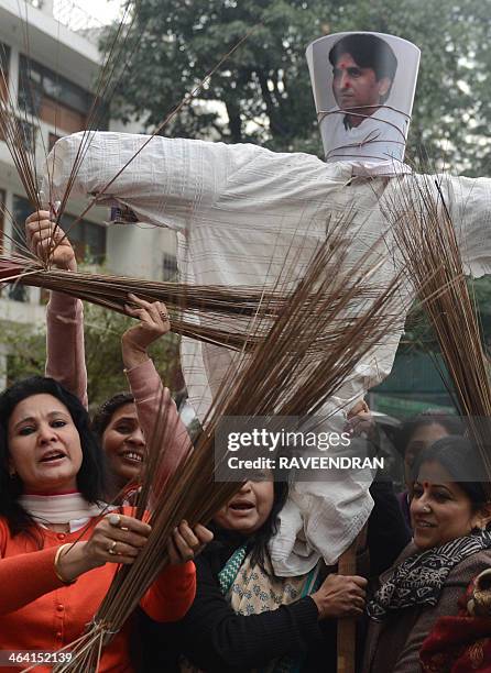 Indian nurses and activists thrash brooms, the symbol of Delhi Chief Minister Arvind Kejriwal's Aam Aadmi Party, as they shout slogans and carry an...