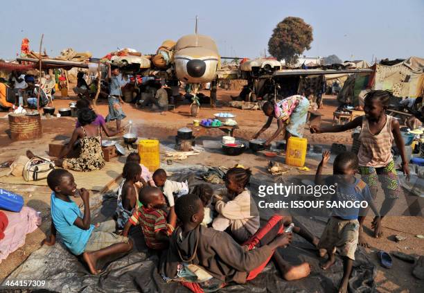 People stand by a plane in the camp for displaced persons at the Mpoko airport in Bangui on January 21 a day after the election of Catherine...