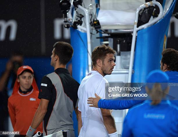 Switzerland's Stanislas Wawrinka walks off court during a rain shower in his men's singles match against Serbia's Novak Djokovic on day nine at the...