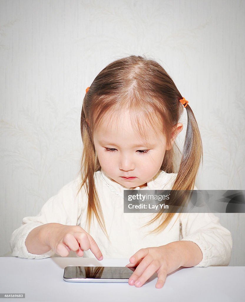 Toddler girl playing with smartphone