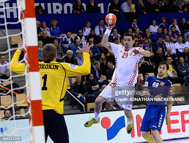 Croatia's left wing Ivan Nincevic jumps to score past Russia's goalkeeper Nikolay Sorokin during the men's EHF Euro 2014 Handball Championship main...