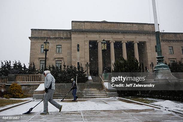 Workers clear snow from the Trenton War Memorial prior to New Jersey Gov. Chris Christie being sworn in for his second term on January 21, 2014 at...