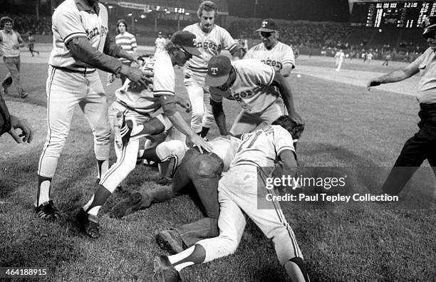 Members of the Texas Rangers take down a drunk fan on the field during a game on June 4, 1974 at Cleveland Municipal Stadium in Cleveland, Ohio....