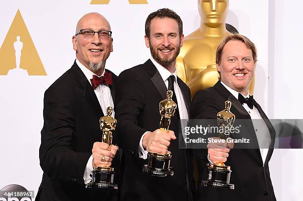Producer Roy Conli and directors Chris Williams and Don Hall pose with their award in the press room during the 87th Annual Academy Awards at Loews...