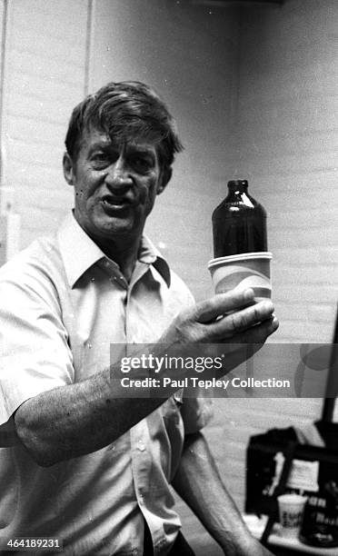 Home plate umpire Larry McCoy holds up a beer botle and cup that was thrown on the field following a game between the Texas Rangers and Cleveland...