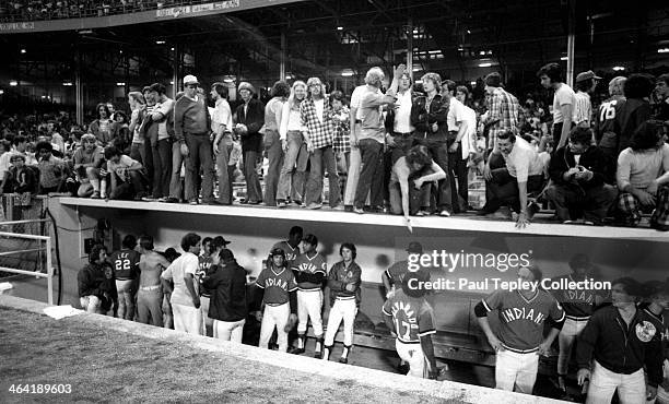 Fans of the Clevleand Indians stand on top of the Cleveland Indians dugout during a game against the Texas Rangers on June 4, 1974 at Cleveland...