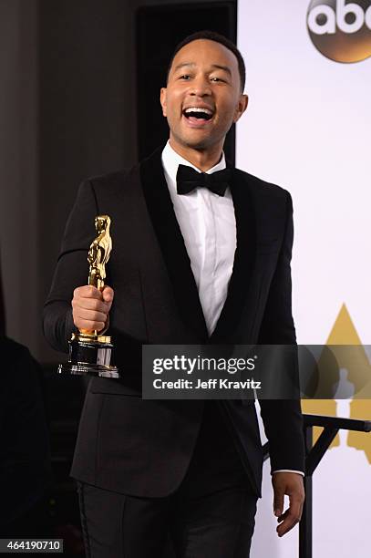 Musician John Legend, with the award for best original song for "Glory", pose in the press room during the 87th Annual Academy Awards at Loews...