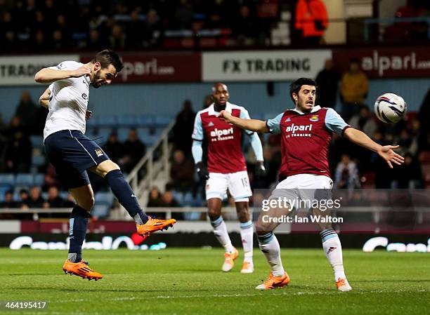 Alvaro Negredo of Manchester City beats James Tomkins of West Ham United to score their first goal during the Capital One Cup Semi-Final, Second Leg...