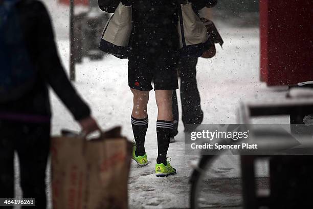 Man walks in shorts in Manhattan during a snowstorm that is moving through the Northeast on January 21, 2014 in New York City. Along with dropping...