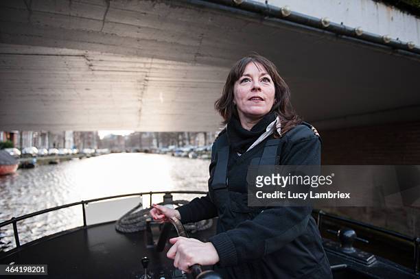 female captain passing a low bridge - boat captain fotografías e imágenes de stock