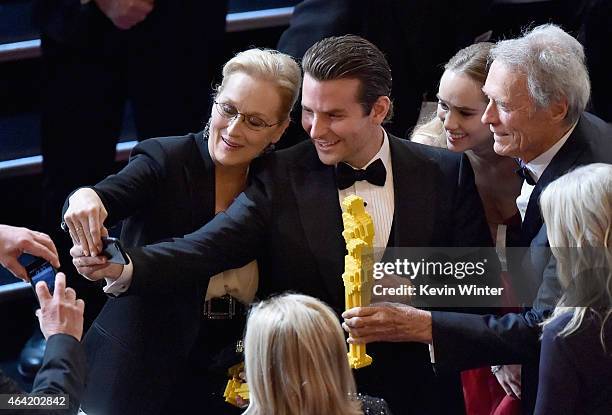 Actors Meryl Streep and Bradley Cooper and actor/director Clint Eastwood take a selfie onstage during the 87th Annual Academy Awards at Dolby Theatre...