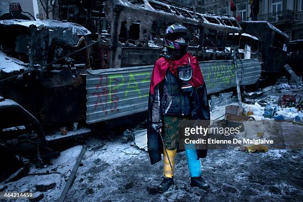 Anti government protester stand next of a charred police truck during standoff with riot units on Hrushevskoho street after consecutives nights of...