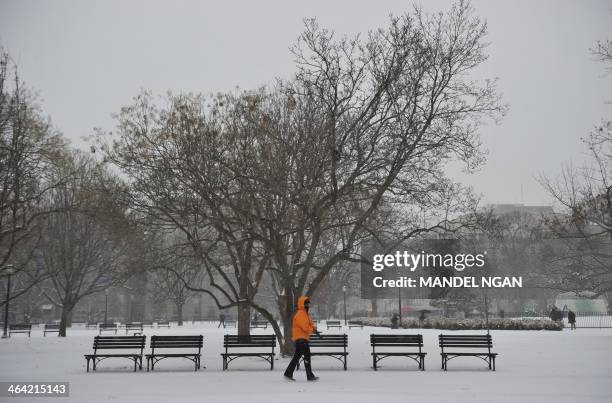 Woman walk past empty park benches at Lafayette Square across from the White House on January 21, 2014 in Washington, DC. The northeastern United...