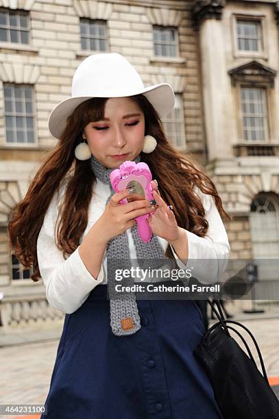 Hayley Hyejin Japanese fashion design student studying at UCA, Epsom holding a Moschino rubber Iphone holder styled as a hand mirror, and wearing...