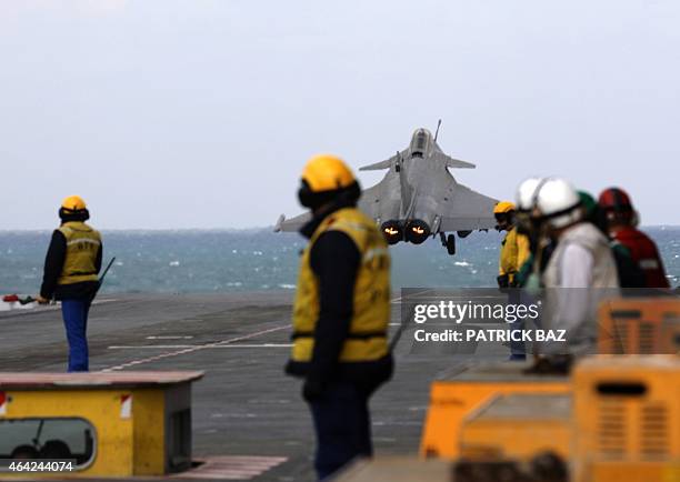 Fligh deck operator leaves the catapult area as a French Navy Rafale fighter jet prepates to take off from the the aircraft carrier Charles de Gaulle...