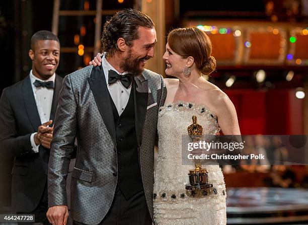 Actor Matthew McConaughey escorts winner Julianne Moore offstage as she holds her statuette for Actress in a Leading Role during the 87th Annual...