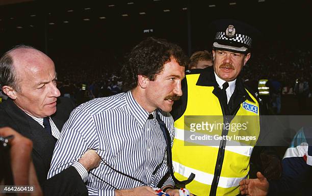 Rangers manager Graeme Souness is escorted off the field after Rangers had clinched the League title for the 1989/90 season by beating Dundee United...