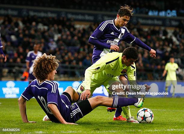 Mohamed El Ouriachi of Barcelona battles for the ball with Samy Bourard and Wout Faes of Anderlecht during the UEFA Youth League Round of 16 match...