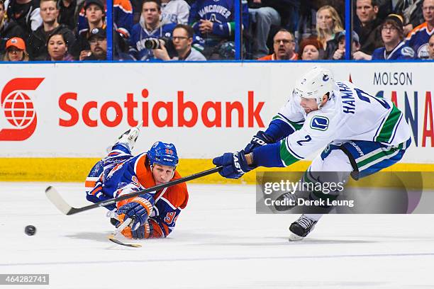 Ryan Smyth of the Edmonton Oilers reaches to check Dan Hamhuis of the Vancouver Canucks during an NHL game at Rexall Place on January 21, 2014 in...