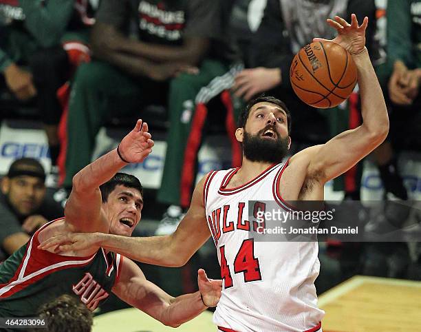 Nikola Mirotic of the Chicago Bulls rebounds over Ersan Ilyasova of the Milwaukee Bucks at the United Center on February 23, 2015 in Chicago,...