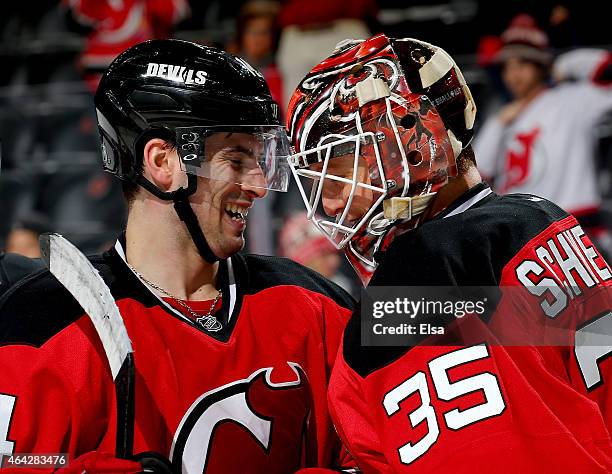 Adam Henrique of the New Jersey Devils congratulates Cory Schneider after Schneider shut out the Arizona Coyotes on February 23, 2015 at the...