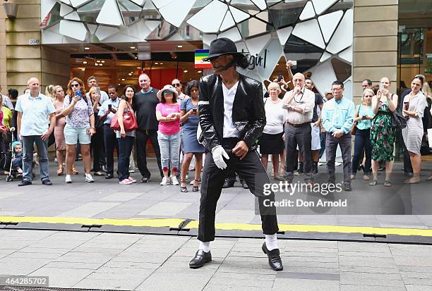 Shoppers look on as Sean Christopher performs during a Michael Jackson 'Moonwalking' demonstration at Pitt St Mall on February 24, 2015 in Sydney,...