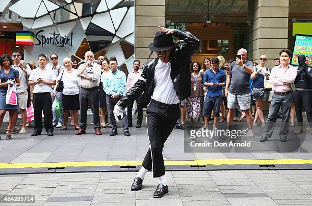 Shoppers look on as Sean Christopher performs during a Michael Jackson 'Moonwalking' demonstration at Pitt St Mall on February 24, 2015 in Sydney,...