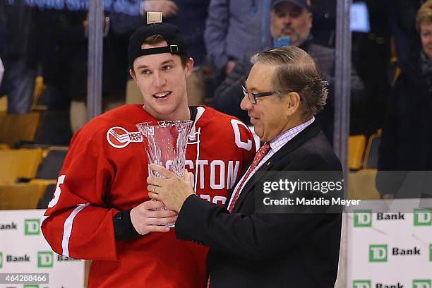 Matt Grzelcyk of the Boston University Terriers is awarded the MVP trophy after the Terriers defeat the Northeastern Huskies 4-3 in overtime during...