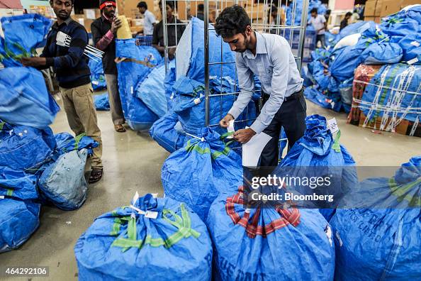A Blue Dart Express employee applies a label to a bag