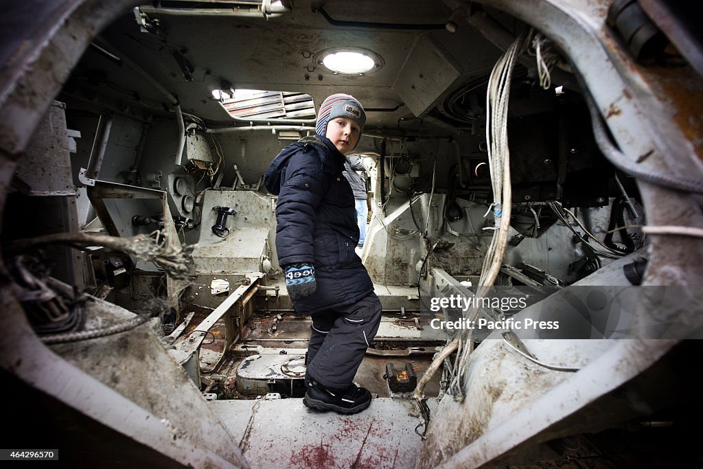 A child goes inside the captured Russian armoured vehicles.