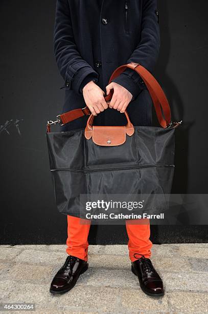 Dylan Tang holding a Longchap bag and wearing a Strelleson trench, knightsbridge trousers, and Clarkes shoesduring London Fashion Week Fall/Winter...