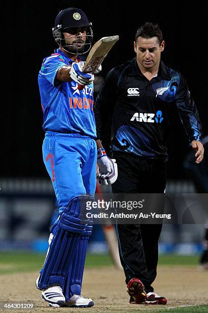 Virat Kohli of India celebrates his half century as Nathan McCullum of New Zealand looks on during the One Day International match between New...