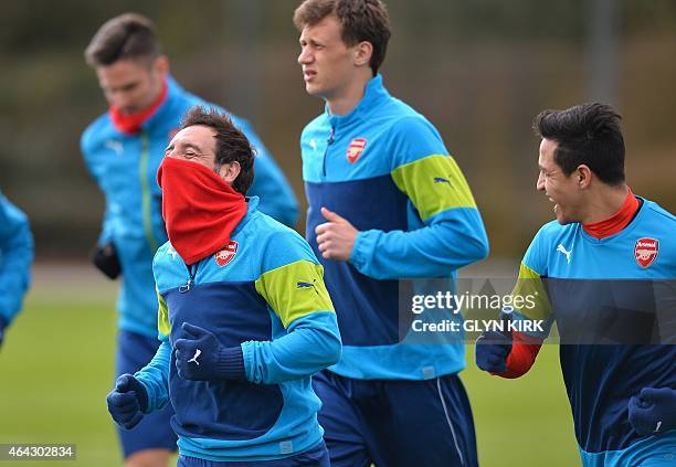 Arsenal's Spanish midfielder Santi Cazorla shares a joke with Arsenal's Chilean striker Alexis Sanchez during a training session at Arsenal's...
