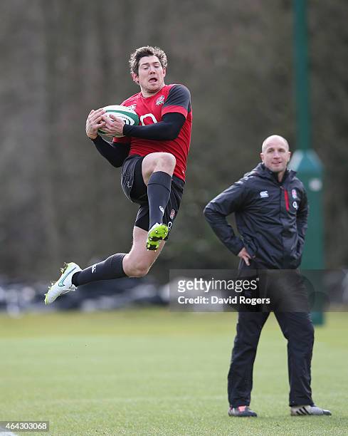 Alex Goode catches the high ball watched by coach Mike Catt during the England training session held at Pennyhill Park on February 24, 2015 in...